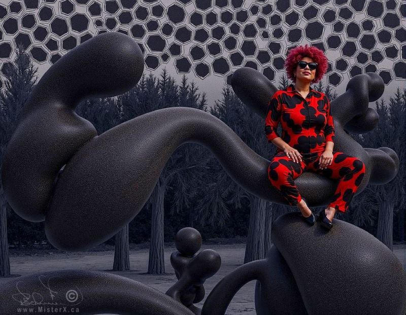 Surreal image shows a woman in a black and red jump-suit sitting on a shiny shape which appears to float in a forested background with geometrically shaped sky.